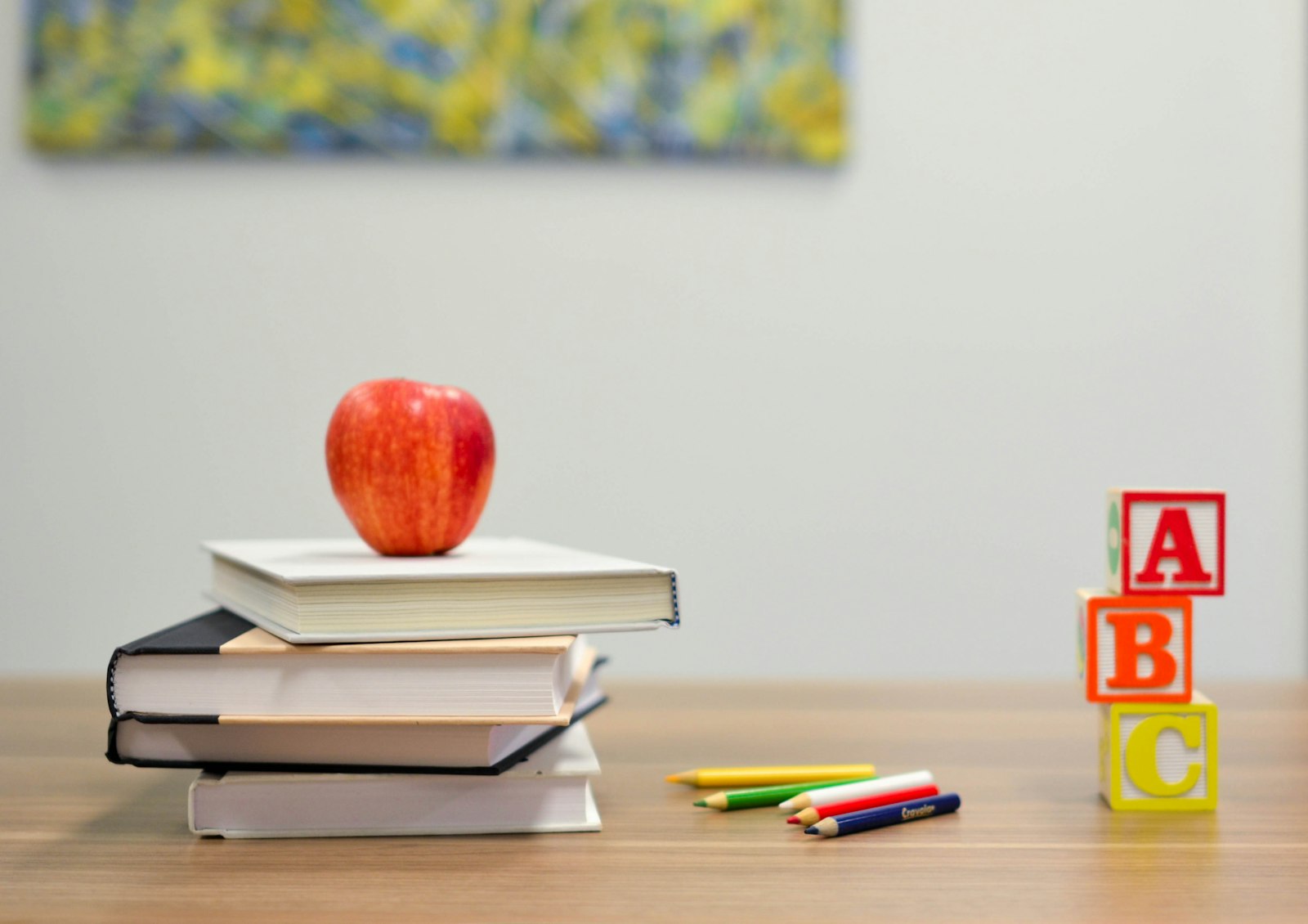 School books, pencils and alphabet blocks on a desk