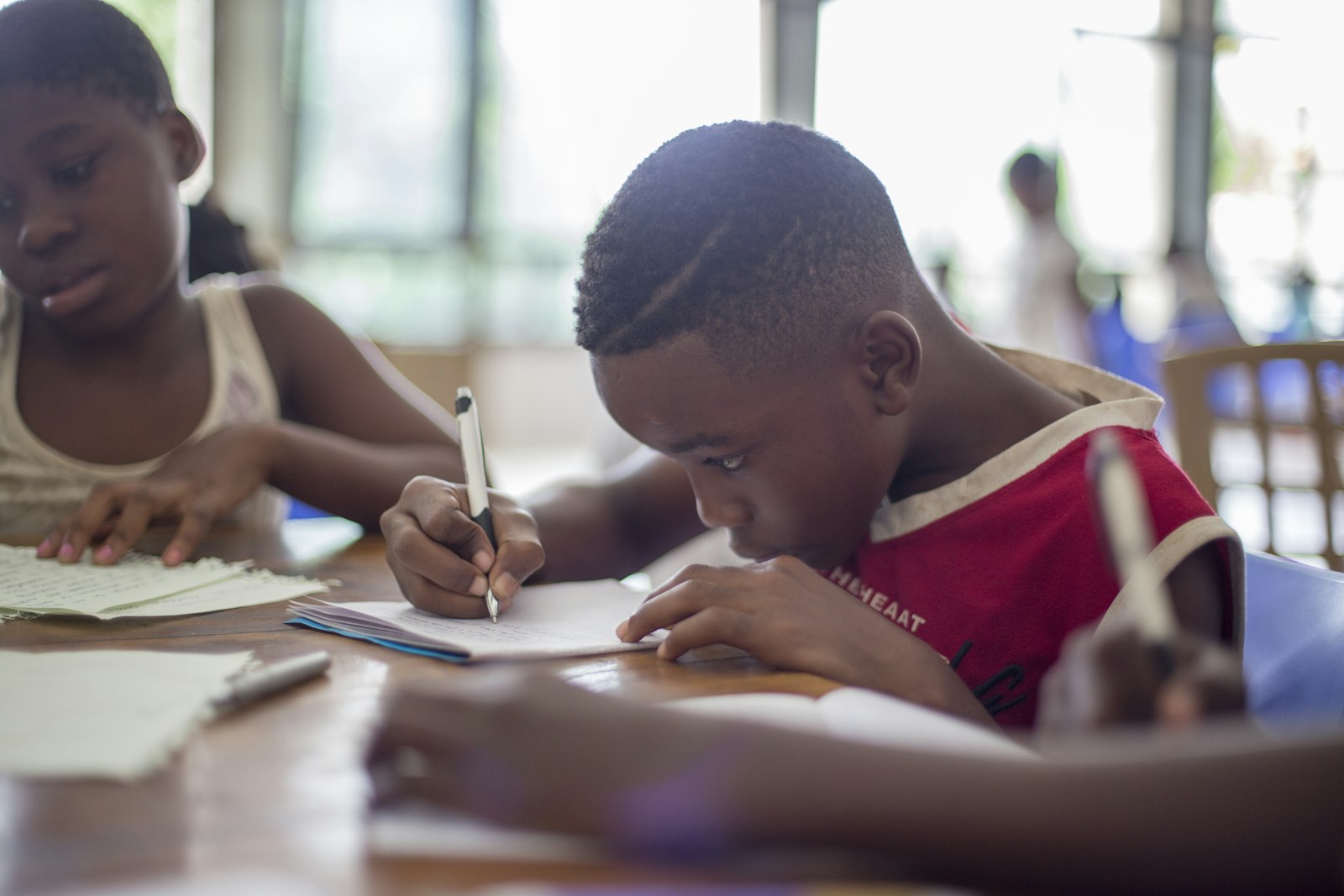 A small group of students writing together at a weekend tuition session