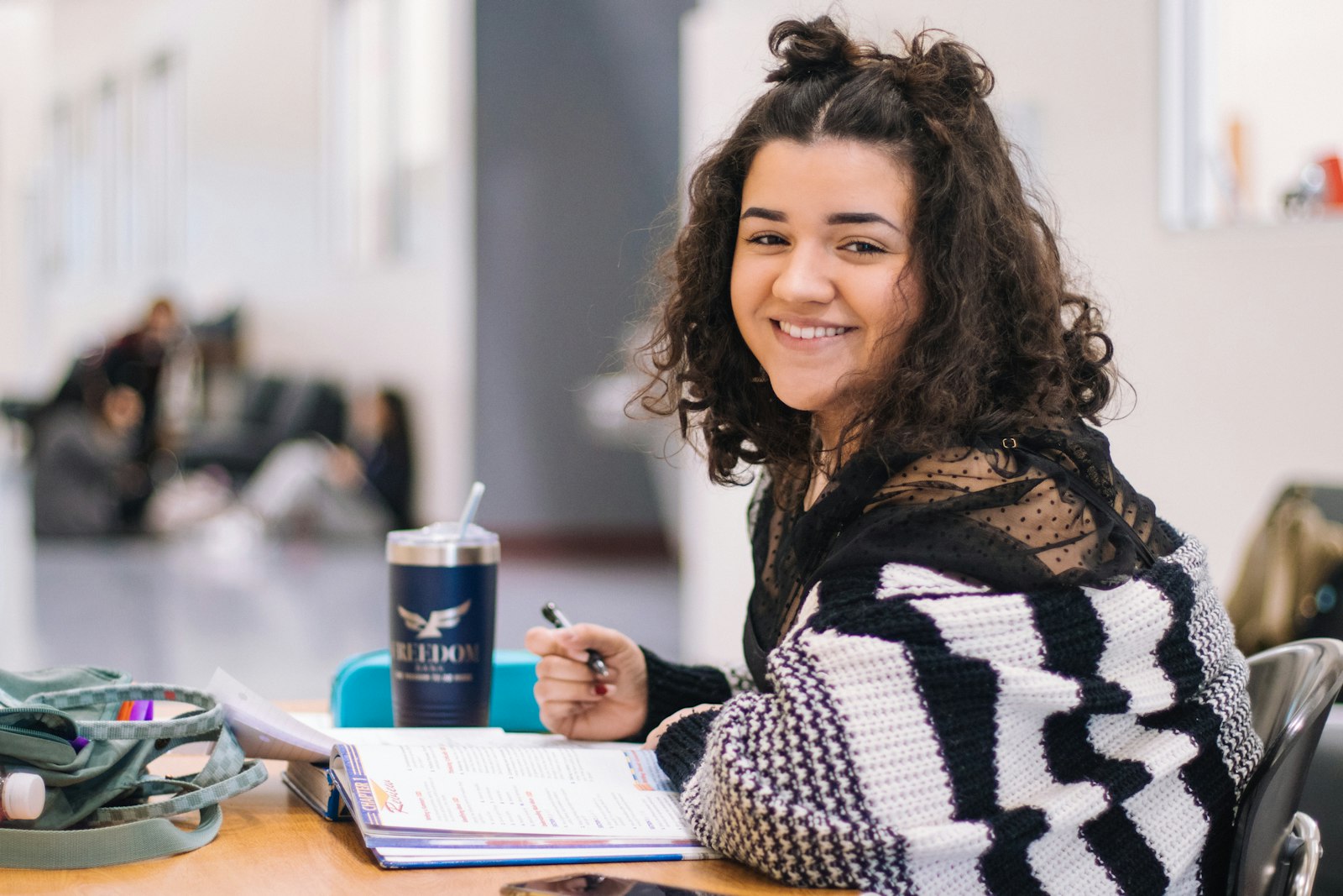 A smiling student working through a revision book
